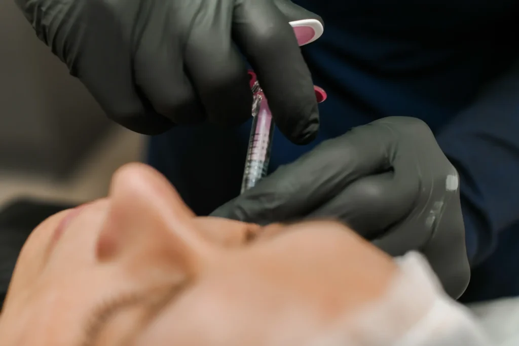 Injecting dermal fillers into a woman's cheek