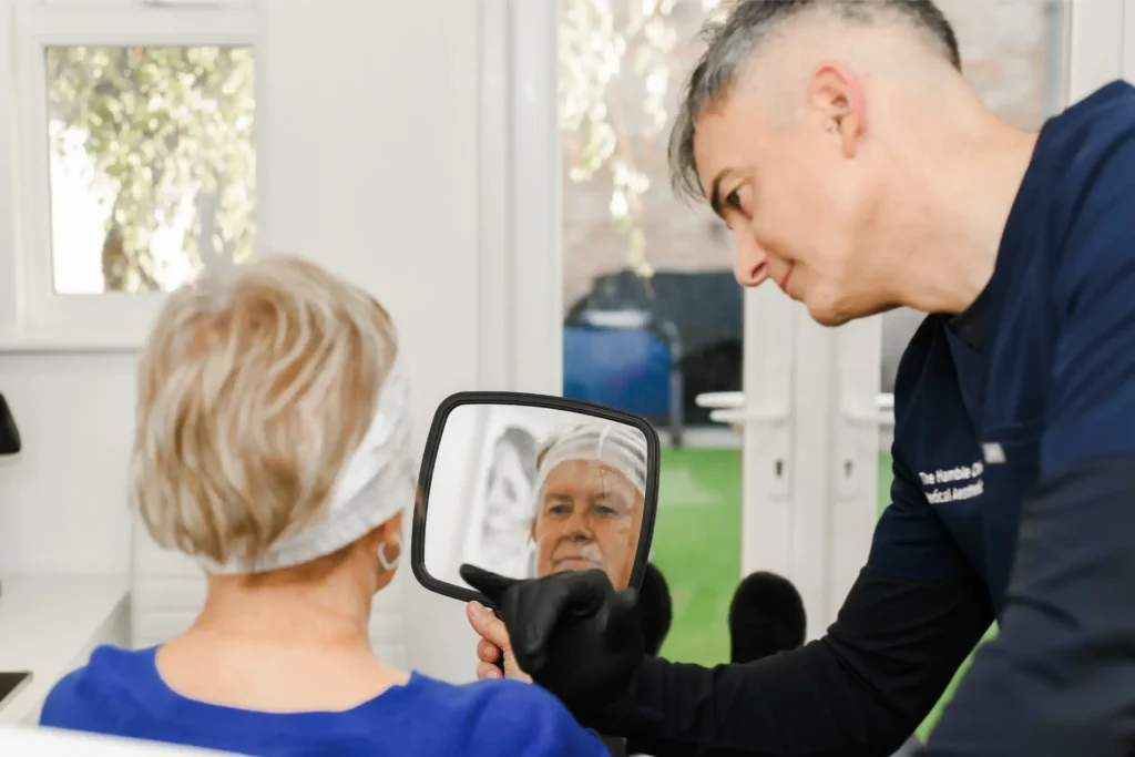 A woman looking into a mirror during a consultation