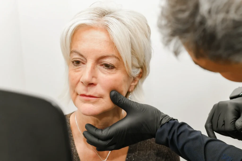 Woman looking into a mirror whilst stuart performs a consultation